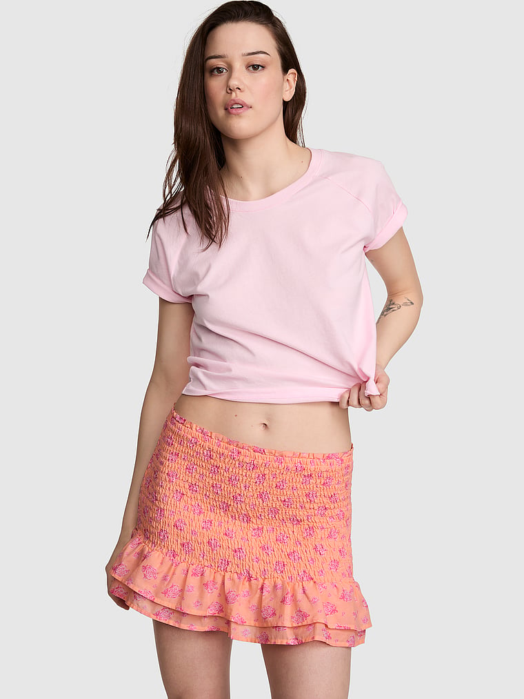 PINK Flirty Fit Smocked Mini Skirt, Peach Floral, onModelFront, 1 of 3 Sofia is 5'10" and wears Small
